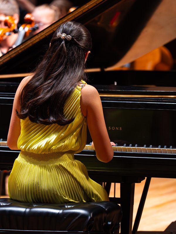 Anna playing piano with an orchestra behind her