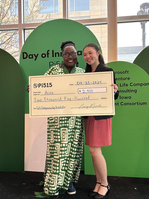 Anna holding a Pi515 award check for the Girls Entrepreneurship Incubator